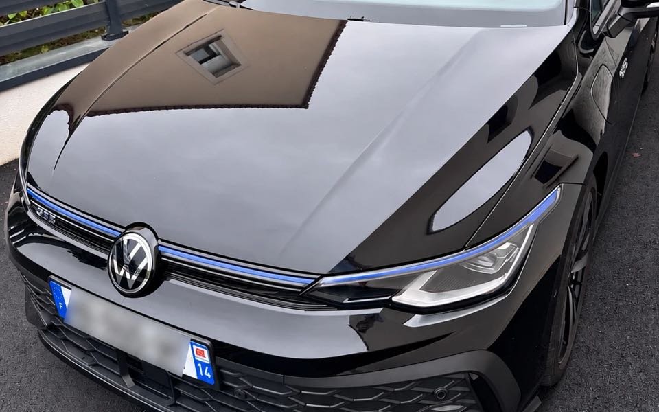 Carrosserie noire brillante après lavage : capot, calandre et phare